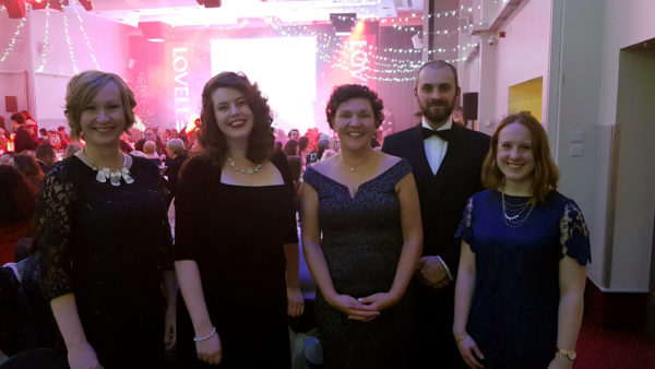 Tai Pawb staff in formal wear standing in a ball room
