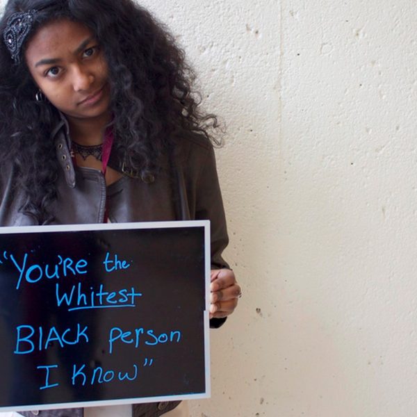 Image of a young black girl holding a sign that says you're the whitest black person i know