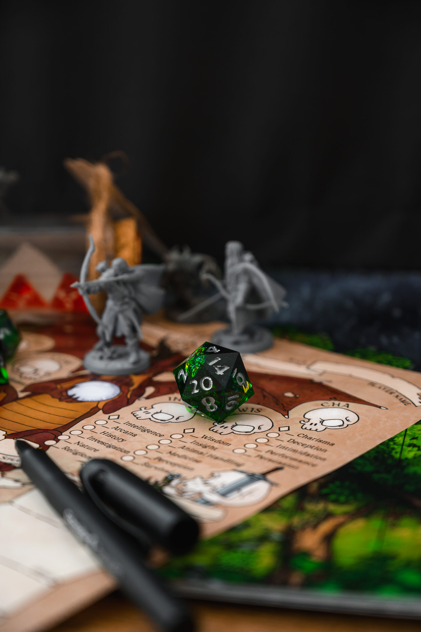 Focus on d20 die. Blurred background with monster miniatures for board games. Dice game, RPG